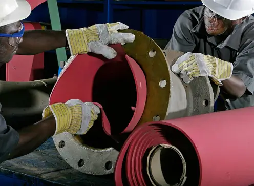 A photo showing a worker applying Linatex rubber lining to a steel pipe. This highly wear-resistant natural rubber lining significantly enhances the durability of pipes and equipment. DEF RUBBER, as the manufacturer of this Linatex-type wear-resistant material, offers a strong competitor to traditional Linatex rubber, providing the same high quality at a more cost-effective price.