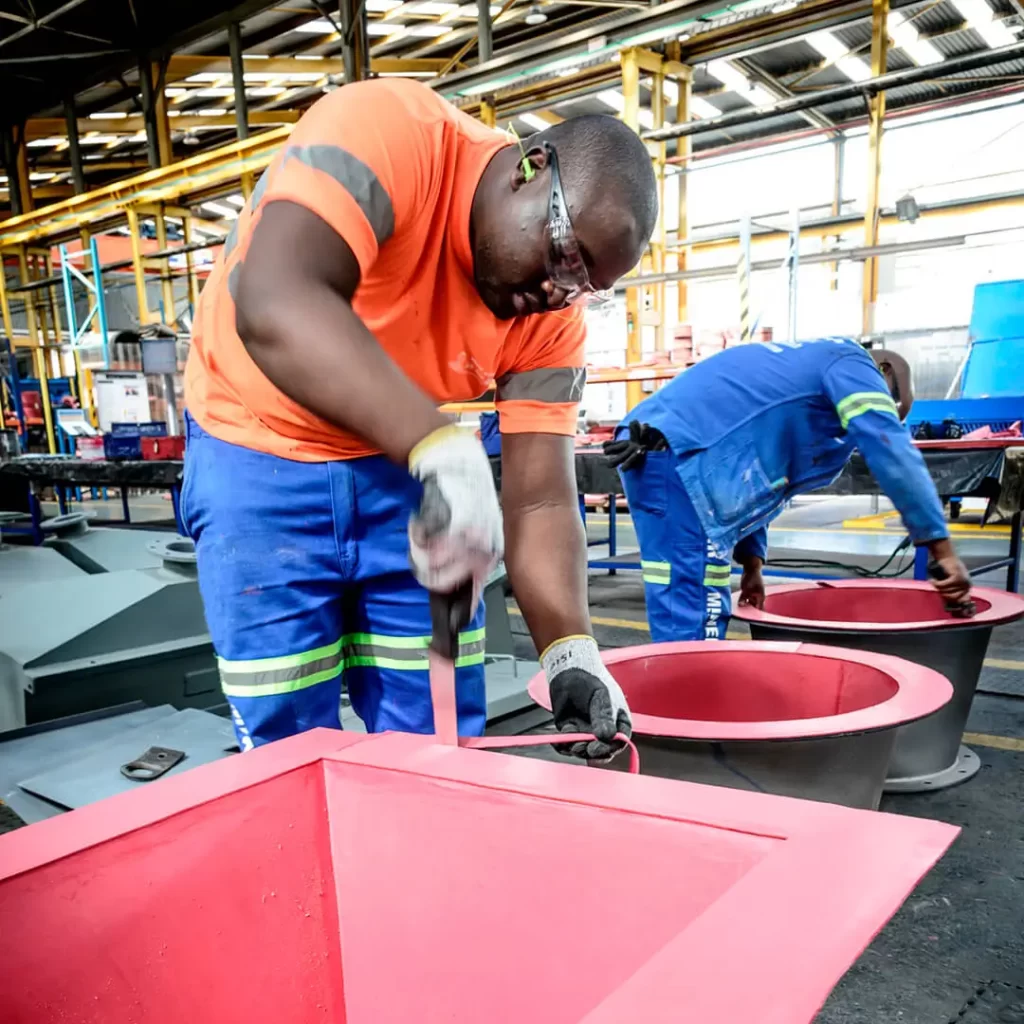 Process of trimming excess rubber during the manufacture of wear-resistant rubber linings. Excess material is left during bonding to ensure complete coverage of the internal surface, ensuring thorough protection.